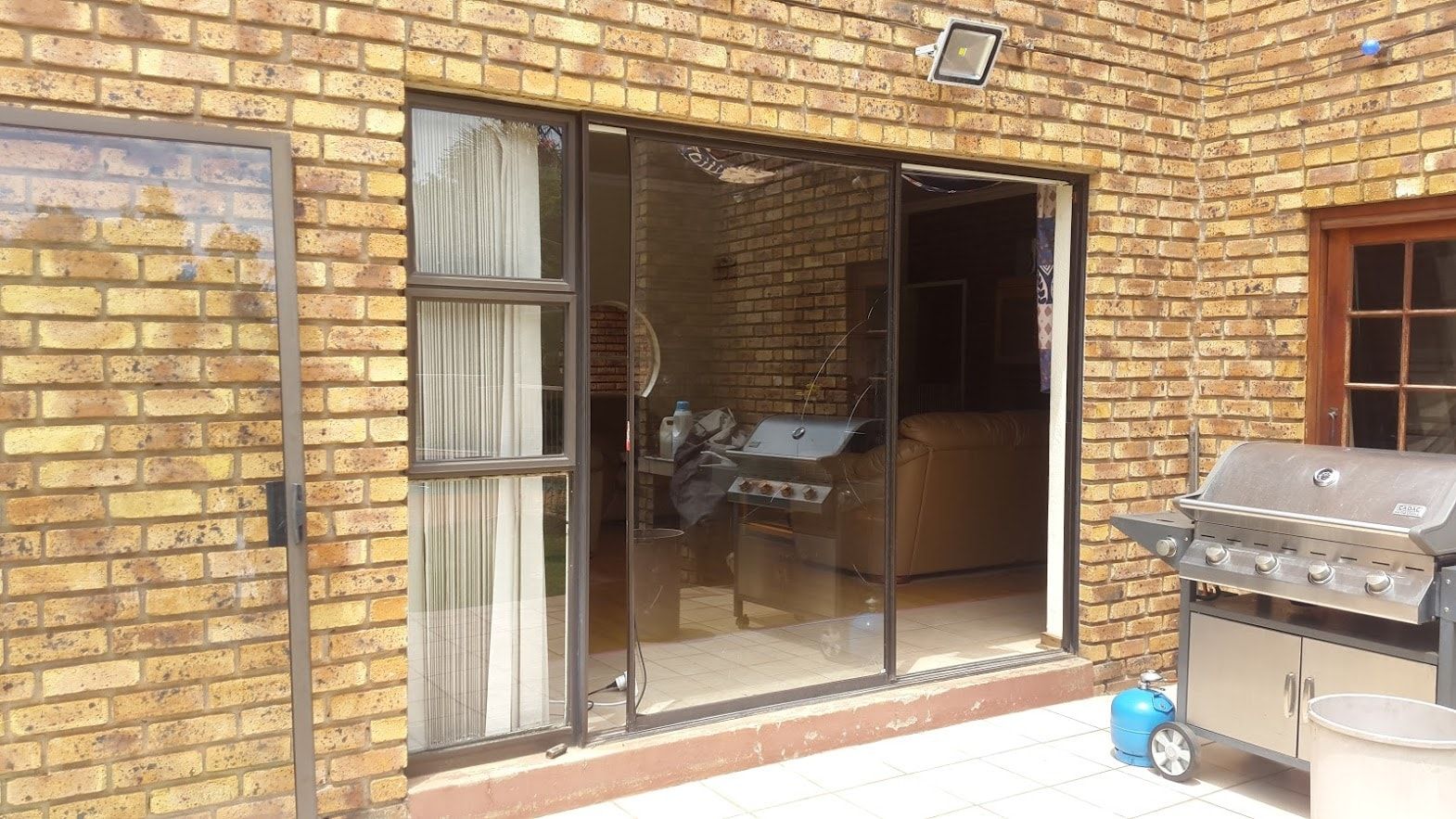 Aluminium sliding door in a face-brick wall, repaired and back in use